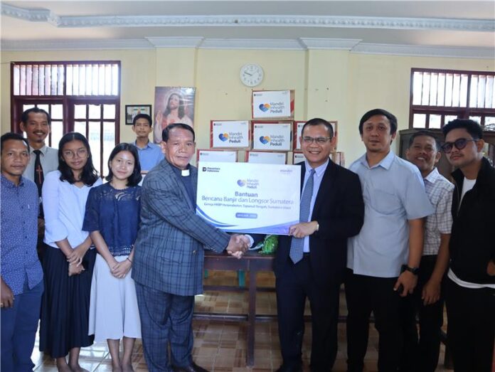 Plt. Direktur Utama Mandiri Inhealth, Marihot H. Tambunan (keempat dari kanan), penyerahan bantuan kepada Gereja HKBP Hutanabolon, Kecamatan Tukka.